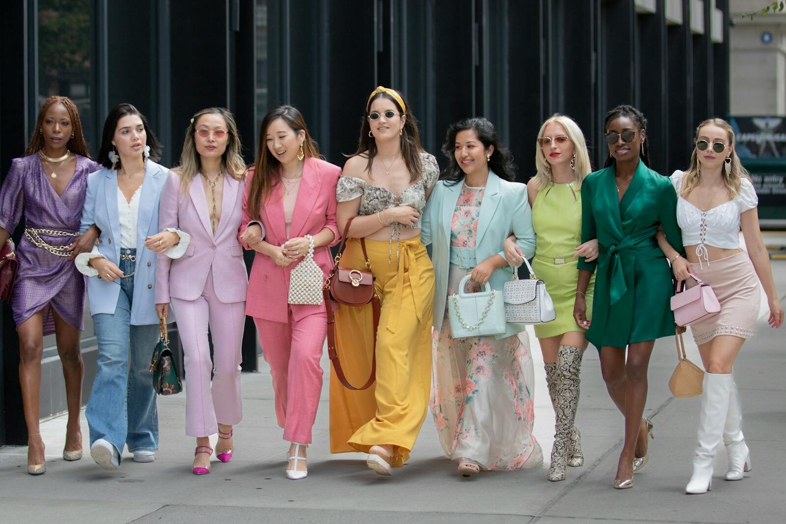 Group of stylish women walking together in vibrant outfits in New York City.